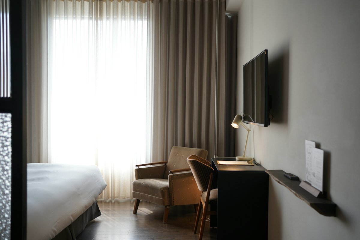 A made-up hotel room with warm lighting